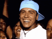 a man wearing a blue hat and white shirt is smiling