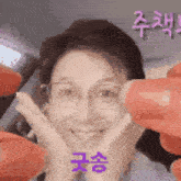 a woman wearing glasses is making a funny face while being held by a person .