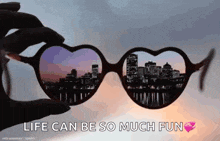 a person is holding a pair of heart shaped sunglasses with the words life can be so much fun on the bottom