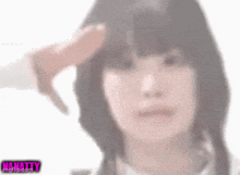 a blurry picture of a woman saluting with her hand on her head .