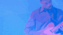 a man playing a guitar on a stage in front of a city skyline