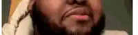 a close up of a man 's face with a beard wearing a scarf .