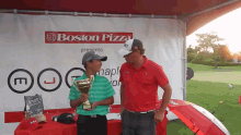 a man holding a trophy in front of a boston pizza banner