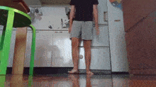 a man in shorts is standing in a kitchen
