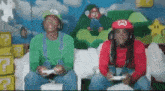 two men dressed as mario and luigi are playing a video game on a couch .