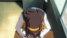 a girl with a bow on her head sits at a desk in front of a window