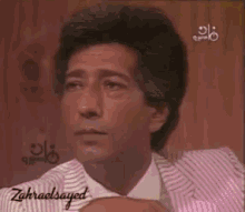 a man in a pink and white striped suit and tie has the name zahraelsayed on the bottom