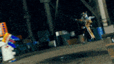 a man in a costume is holding a sword in a dark area