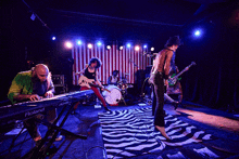 a roland keyboard is on the stage with a band