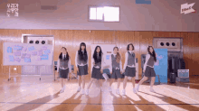 a group of girls are dancing in a gym with a sign that says jtbc
