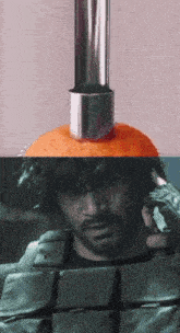 a close up of a man 's face with an orange on top of it