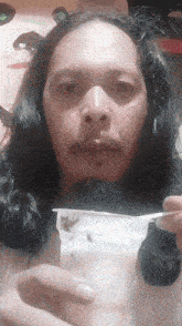 a man with long hair and a beard is holding a cup of yogurt