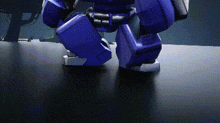 a close up of a blue robot 's legs on a dark surface