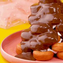 a pile of chocolate covered donuts on a plate