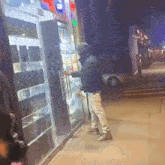 a man in a hooded jacket stands in front of a store
