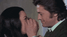 a man and a woman are touching their faces