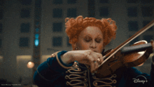 a woman playing a violin with a disney logo in the corner