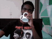 a man wearing a snoop dogg shirt drinks from a cup