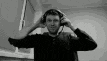 a man wearing headphones is standing in front of a window .