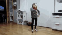 a child wearing a bearded mask is dancing in a room