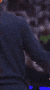a man wearing a blue shirt with a mercedes logo on the front