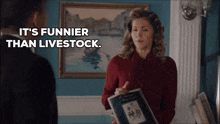 a woman holding a book with the words it 's funnier than livestock