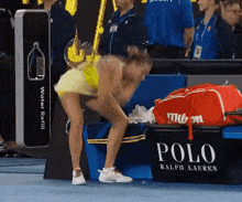 a woman squatting down in front of a polo ralph lauren sign