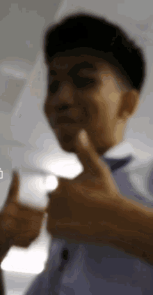 a blurry picture of a young man giving a thumbs up