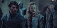 a man and a woman are standing next to each other .