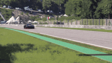 a car is driving down a race track with a green line