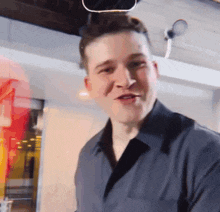 a man in a black shirt is smiling and looking to the side