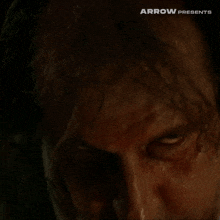 a close up of a man 's face with the words arrow presents visible