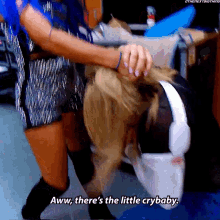 a woman is holding another woman 's head and says aww there 's the little crybaby .