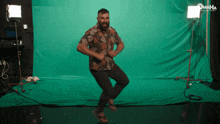 a man is dancing in front of a green screen with omaha written on it