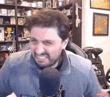 a man in front of a microphone with a sticker that says thinkrules on it