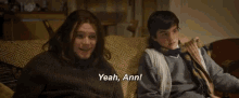a man and a boy are sitting on a couch and the boy is saying yeah , ann .