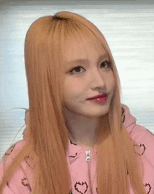 the girl is wearing a pink hoodie with hearts on it
