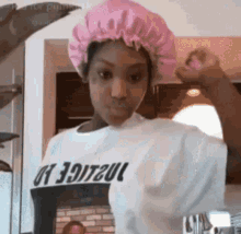 a woman wearing a pink hat and a white shirt is standing in a room .