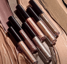 several bottles of glitter shadow are lined up on a surface