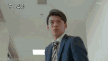 a man in a suit and tie is standing in a room .