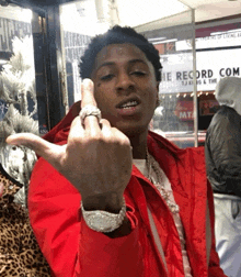 a man wearing a red jacket giving the middle finger