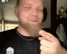 a man wearing a black shirt with a skull on it is smoking a cigarette