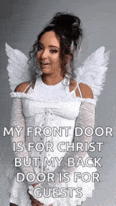 a woman dressed as an angel is standing in front of a door .