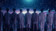 a group of people standing in front of a starry sky with a galaxy in the background