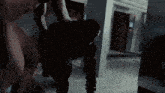 a man is holding a gun in a room with a sign that says h