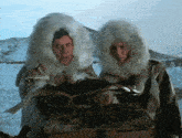 two men in fur coats looking at a box