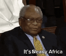 a man in a suit and tie with the words it 's nearly africa behind him