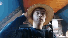 a boy wearing a straw hat and a mountain retro sweatshirt