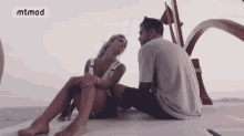 a man and a woman are sitting on the deck of a boat .