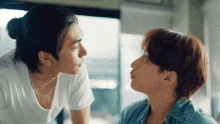 a man and a woman are looking at each other and kissing each other .